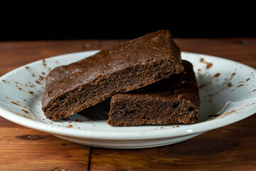 Brownie on white plate with black background