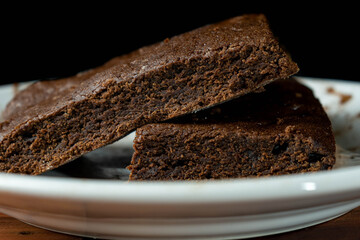 Brownie on white plate with black background
