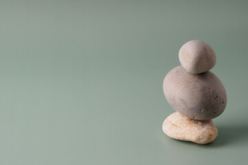 Fototapeta na wymiar A stack of sea stones on a pastel background. Balance concept, copy space. Spiritual relaxation, zen. Pyramid of pebbles, harmony, simplicity, minimalism