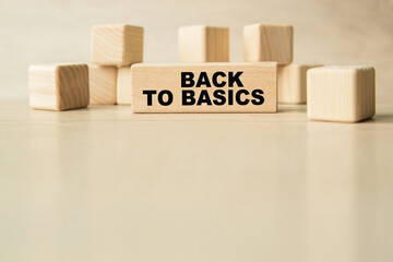the words BACK TO BASICS are written on a wooden cubes structure. Cube on a bright background. Can be used for business, financial concept. Selective focus. copy space