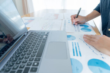 Businessman hand analyzing chart on paper investment charts with laptop. Accounting. Business concept