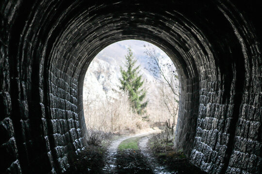 An Abandoned Tunnel Through Which A Train Once Passed Has Long Since Grown Into Greenery
