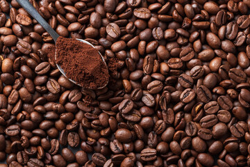 coffee beans background with coffee beans and a teaspoon of ground coffee