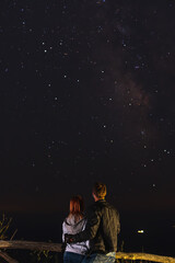 Couple traveler enjoying watched the star and milky way galaxy over the sky on top of the mountain....