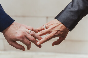 wedding gay couple holding hands with engagement rings - 427976905