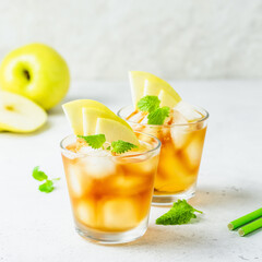 Spicy summer apple cocktail, apple iced tea in glasses. Space for text.