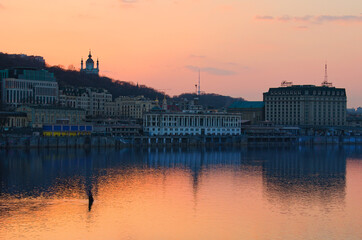 Obraz premium Amazing sunset landscape view of Poshtova Square with white River Port building and other historical buildings. Embankment of Dnipro River. Dramatic colorful sunset