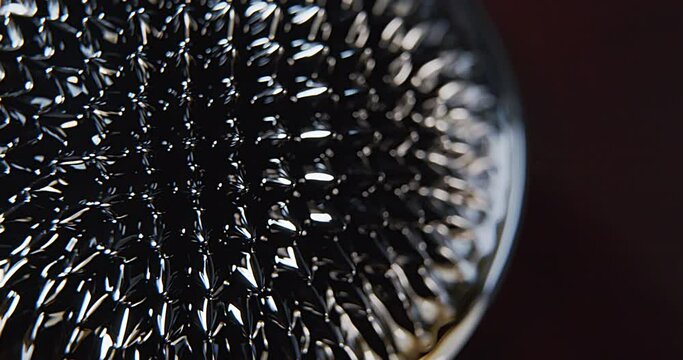 Macro shoot of a black abstract ferro fluid with moving lights
