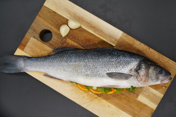 Seabass ready prepared for oven with garlic, orange slices and coriander