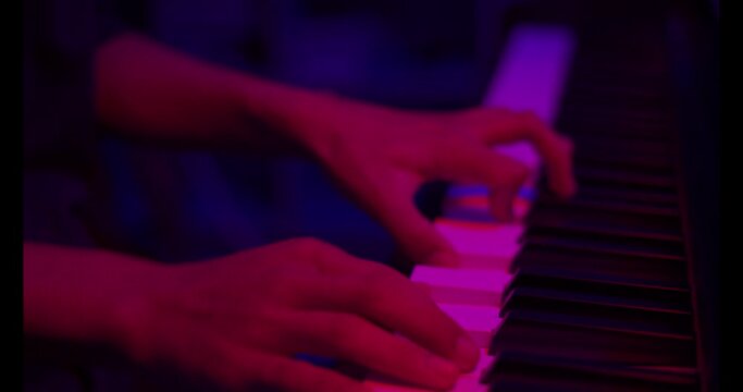 Close up of finger musician at the piano , The pianist playing  piano in the room ,classic piano,neon light,funny,hobby.