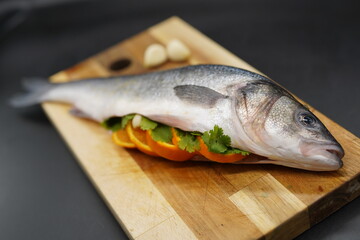 Seabass ready prepared for oven with garlic, orange slices and coriander