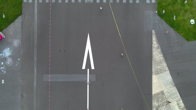 Aerial drone shot of person riding bike at Berlin Tempelhof Airport, an area now used as a recreational area after the airport closed in 2008.