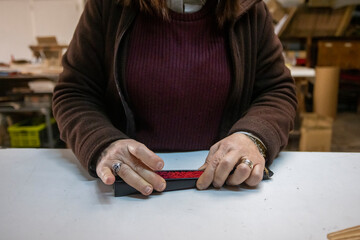 Closeup shot of a Spanish woman working at a hand fan design workshop