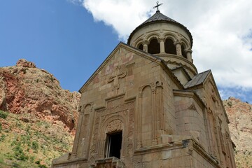 Fototapeta na wymiar Noravank is a 13th-century monastery near the city of Yeghegnadzor, Armenia, located in a narrow gorge of the Amaghu River. The gorge is known for its height and for the steep brick red walls 