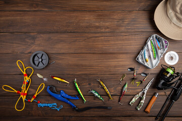 Fishing tackle - fishing spinning rod, hooks and lures on wooden background. Active hobby...