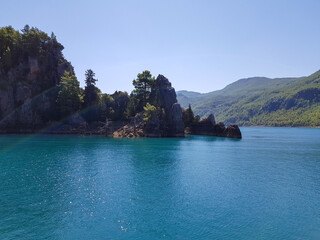 Seascape against the backdrop of mountains on a cloudless sunny day.