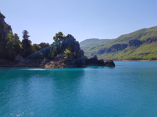Obraz premium Seascape against the backdrop of mountains on a cloudless sunny day.