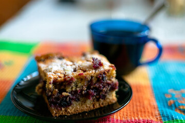 Currant pie and blurred cup of coffee in the background