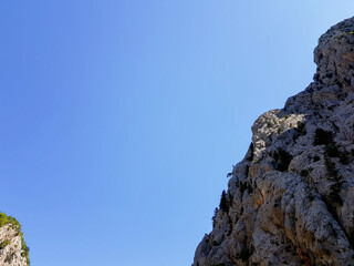 Seascape against the backdrop of mountains on a cloudless sunny day.