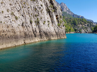 Seascape against the backdrop of mountains on a cloudless sunny day.