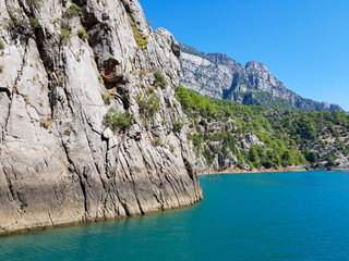 Seascape against the backdrop of mountains on a cloudless sunny day.