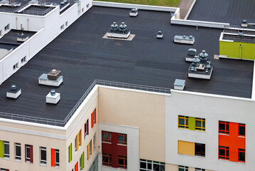 Top view dark flat roof with air conditioners and hydro insulation membranes modern apartment...