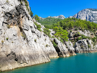 Seascape against the backdrop of mountains on a cloudless sunny day.