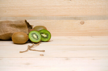 kiwi and a bag of burlap on a wooden background and copy space