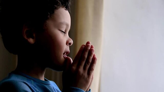 boy praying to God with hands together on white background stock footage