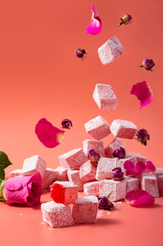 Levitating rose flavored pink Turkish delight with flower petals and dry rose buds