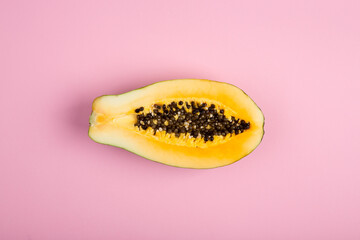 Ripe papaya close-up on pink background. Fresh fruits and vegetables healthy food concept