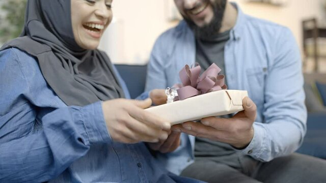 Muslim husband giving birthday present to beloved woman, pleasant surprise