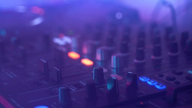 Dj uses Mixing Controller, stroboscopic light and smoke, gimbal shot