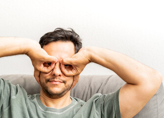 Man making fake glasses with his hands and fingers. Funny picture. Silly face.