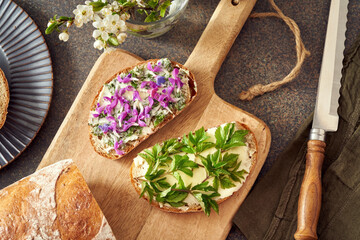 Sourdough bread with wild edible spring plants - young leaves of goutweed, purple dead-nettle and lungwort flowers