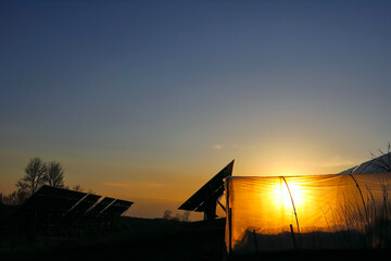 Orange western sun everywhere polyethylene tunnel in the form of a plastic greenhouse against the...