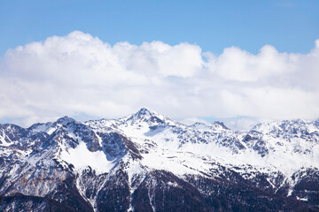 Winter landscape, snowcapped mountains with cloudscape, blue sky. Snowy mountain peaks in Swiss alps, Wallis.