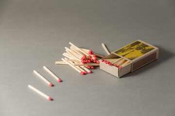 Yellow opened machboxes with stack of dozens red matches.