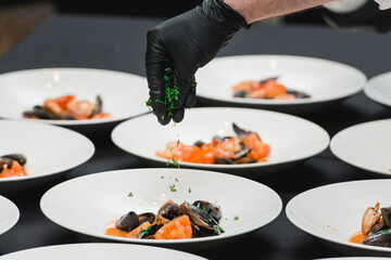 the chef prepares a seafood dish. the cook sets the table for the banquet