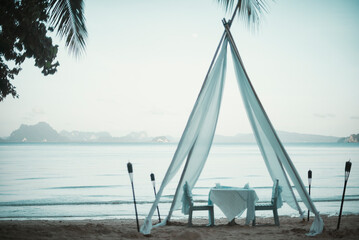 Table and chairs under a romantic fabric arbor on the beach, Koh Yao, Phang Nga, Thailand
