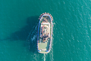 The sea tug moves from the port water area towards the open sea. Photo from the helicopter. View from above.