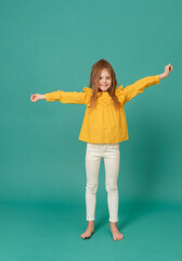  girl in a yellow blouse and white jeans on a green background