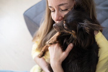 Happy blonde woman hug funny brown russian toy terrier 
