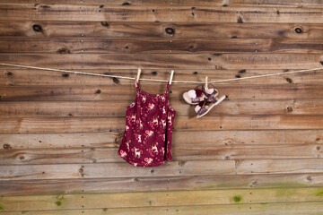 Children's fashion set of girls clothing, dress with sandals; Photo on wooden background.