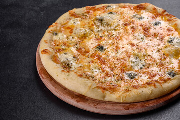 Tasty fresh oven pizza with tomatoes, cheese and mushrooms on a dark concrete background