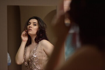 Young girl in dress inside room sits window