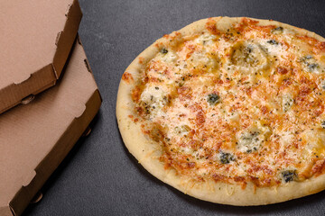 Tasty fresh oven pizza with tomatoes, cheese and mushrooms on a dark concrete background