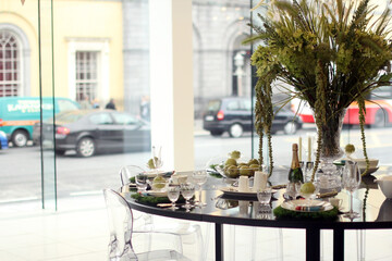 Table elegantly set for a showcase.
Elegant lounge with a table set with a bottle of champagne and a vase of flowers.