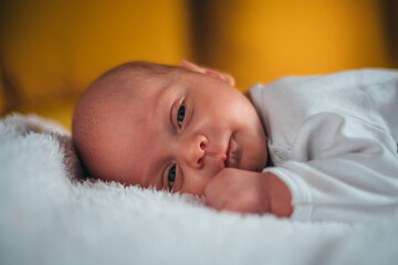 Baby lying on the bed at home