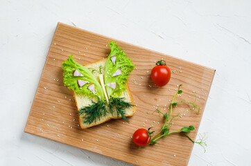 Children's vegetarian sandwich - funny faces. Creative healthy toast. Top view. Healthy vegan food, vegetarian food concept